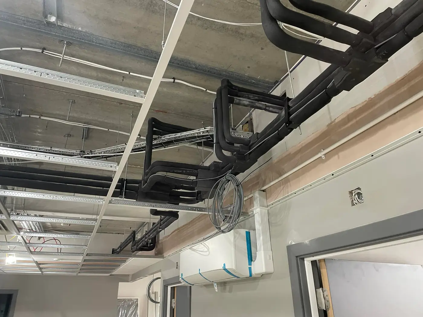 Commercial air conditioning by our Manchester engineers Wall-mounted air conditioning and insulated pipework in a commercial fit-out