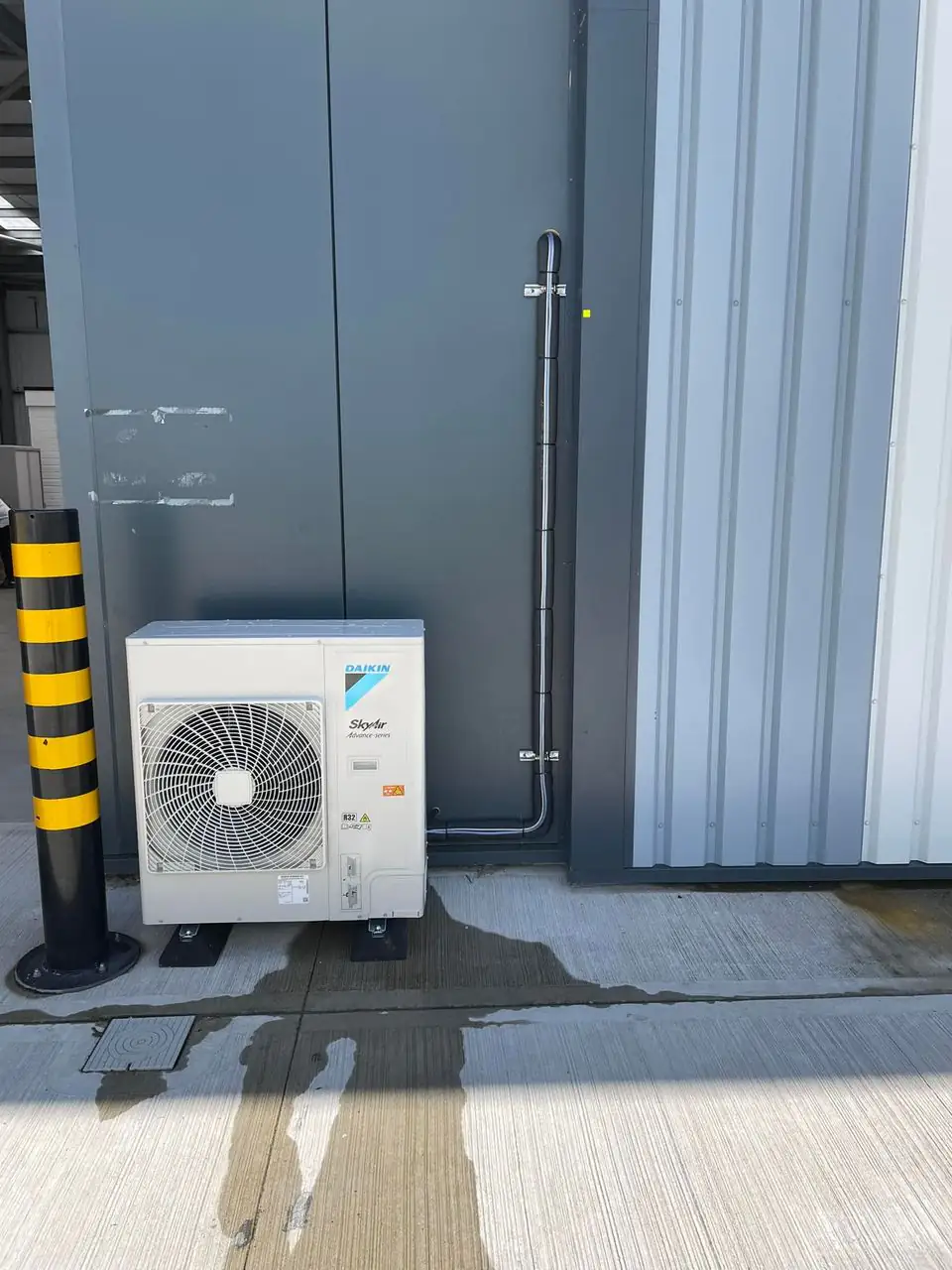 Outdoor unit installation by our Manchester engineers Daikin outdoor condensing unit beside a commercial building
