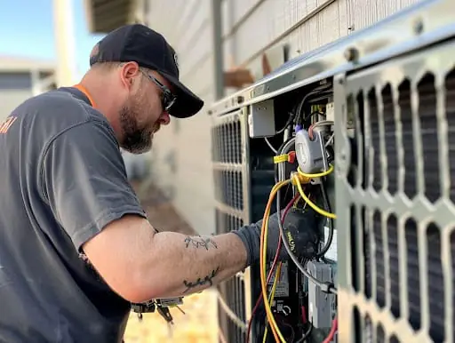 Engineer servicing an outdoor heat pump unit